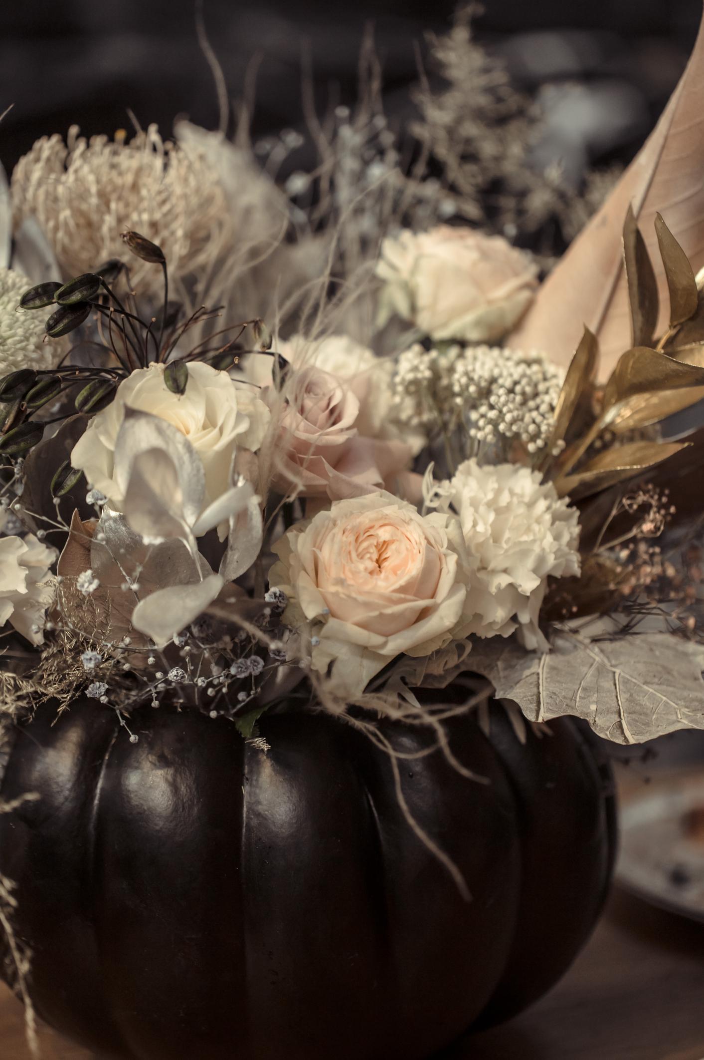 moody Halloween pumpkin centerpiece with dried flowers and dark decor